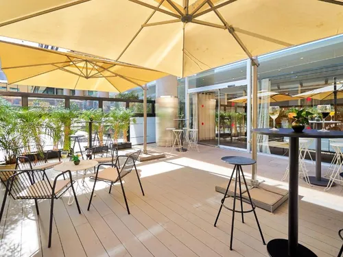 Zona lounge de hotel con tarima composite CDECK®, tono Natural Beech