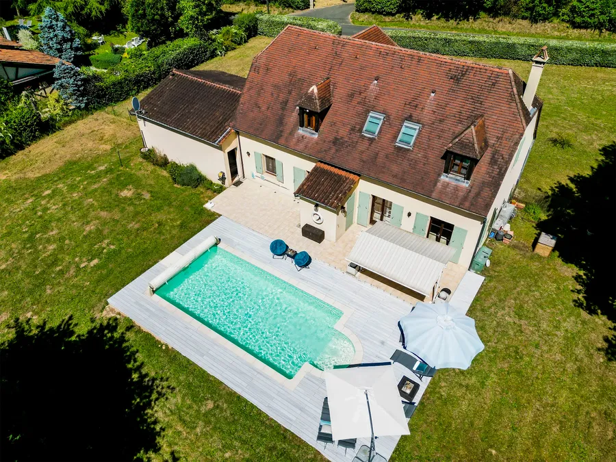 Vue aérienne d'une piscine et sa terrasse en CDECK WUUDE® Nordic Oak, maison à toit de tuiles à Trémolat.