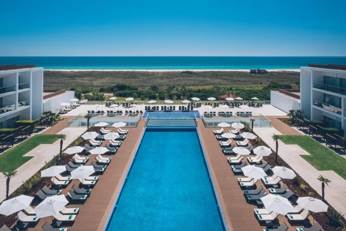 Piscine de l'hôtel Iberostar à Lagos bordée de terrasse CDECK Original® Redwood, océan en fond.