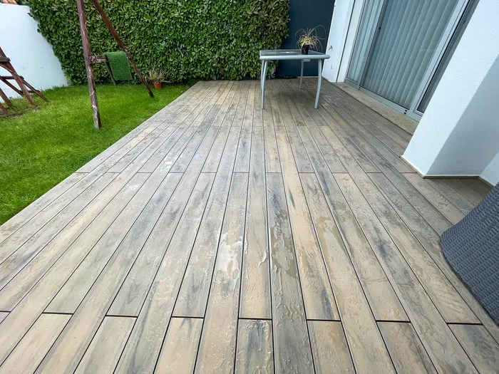 Gros plan sur les lames composites Natural Beech humides, texture bois et veinage apparents.