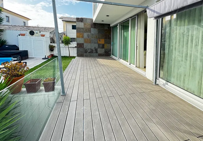 Terrasse en surplomb avec garde-corps vitré, vue plongeante sur la piscine et le jardin.