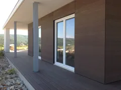 Bardage de façade composite CWALL®, coloris Chocolat : maison de plain-pied avec auvent et terrasse