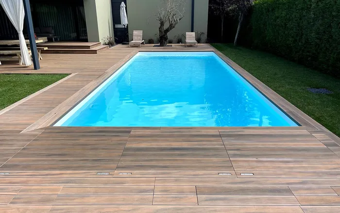 Terrasse composite CDECK WUUDE® Soft Oak en angle de piscine, à Vila do Conde.
