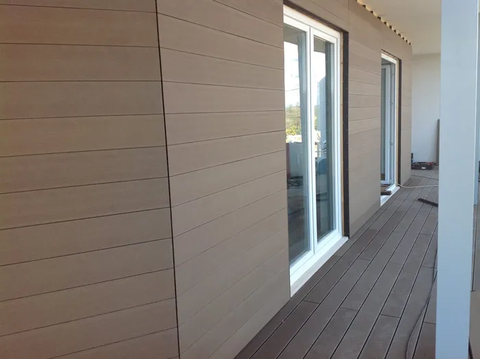 Revestimento de fachada CWALL® em réguas horizontais junto às janelas, deck compósito a acompanhar a varanda.