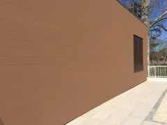 CWALL® façade cladding in Redwood: exterior wall next to a patio