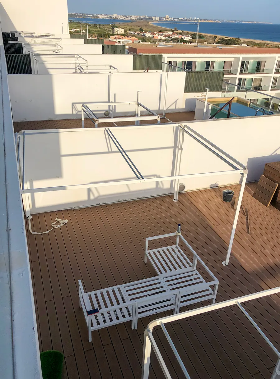 Terrasse en toiture avec mobilier en cours d'installation face à la baie de Lagos.