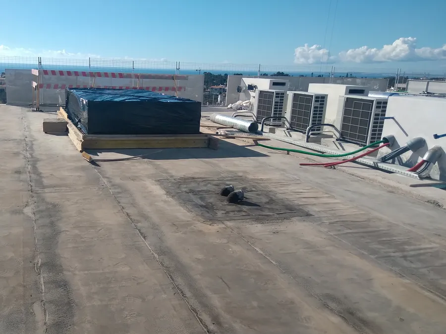 Structure technique protégée par une bâche noire sur la toiture, avant finition de la terrasse.