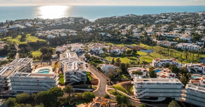Vue aérienne du complexe Nomad Bay à Carvoeiro, face à l'océan au coucher du soleil.