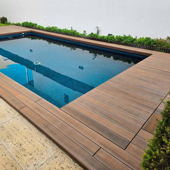 Deck compósito CDECK WUUDE na cor american walnut em zona de piscina residencial