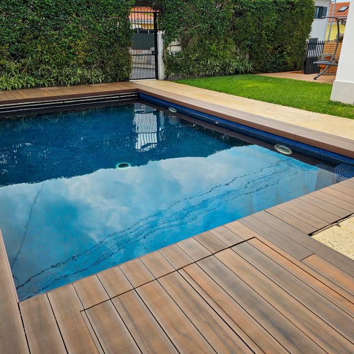 Deck compósito CDECK WUUDE na cor american walnut em zona de piscina residencial