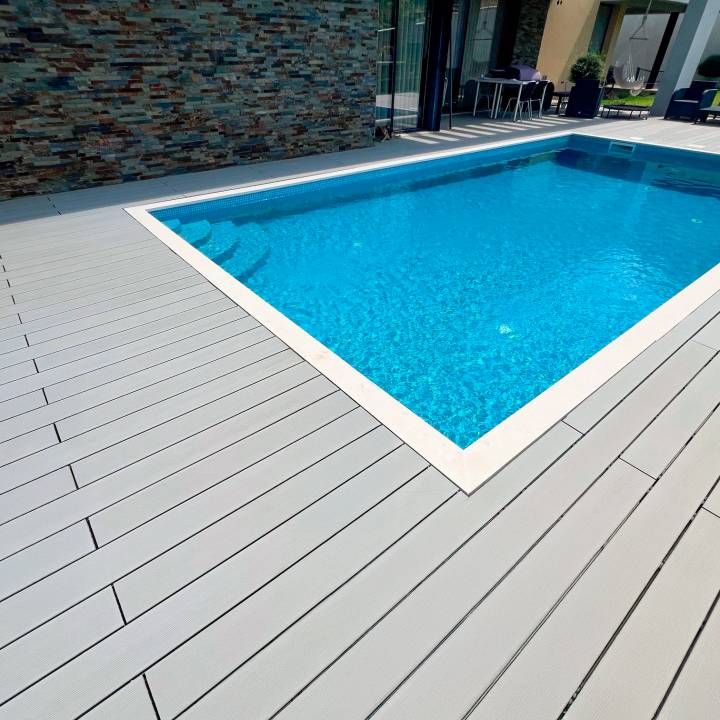 Deck compósito CDECK na cor cinza instalado em zona de piscina residencial