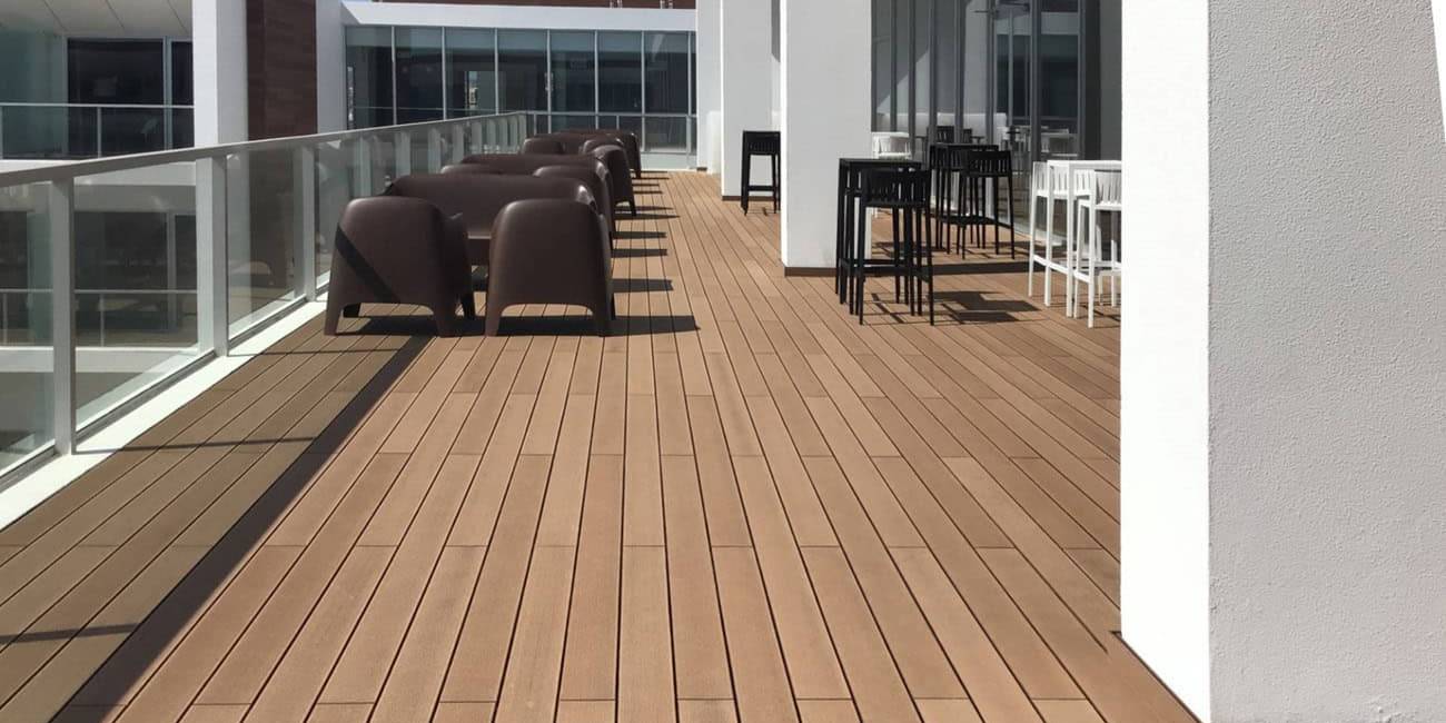 Tarima composite CDECK Original en color redwood en balc&oacute;n comercial