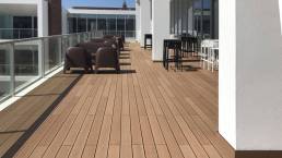 Tarima composite CDECK Original en color redwood en balcón comercial
