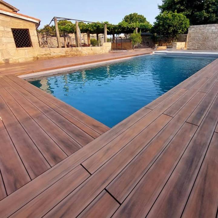Deck compósito CDECK WUUDE na cor american walnut em zona de piscina
