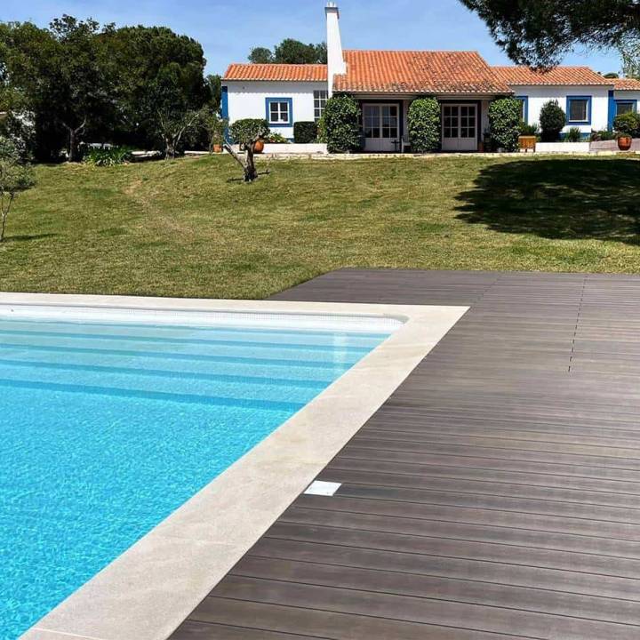 Deck compósito CDECK WUUDE na cor dark walnut em zona de piscina