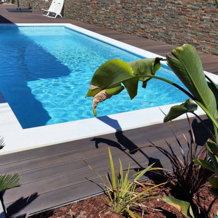 Deck compósito CDECK WUUDE na cor dark walnut em zona de piscina
