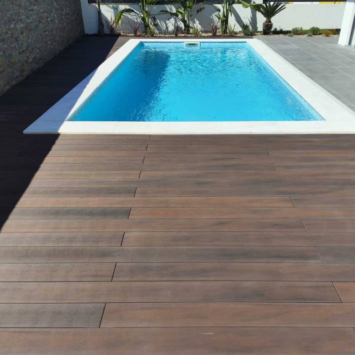 Deck compósito CDECK WUUDE na cor dark walnut em zona de piscina