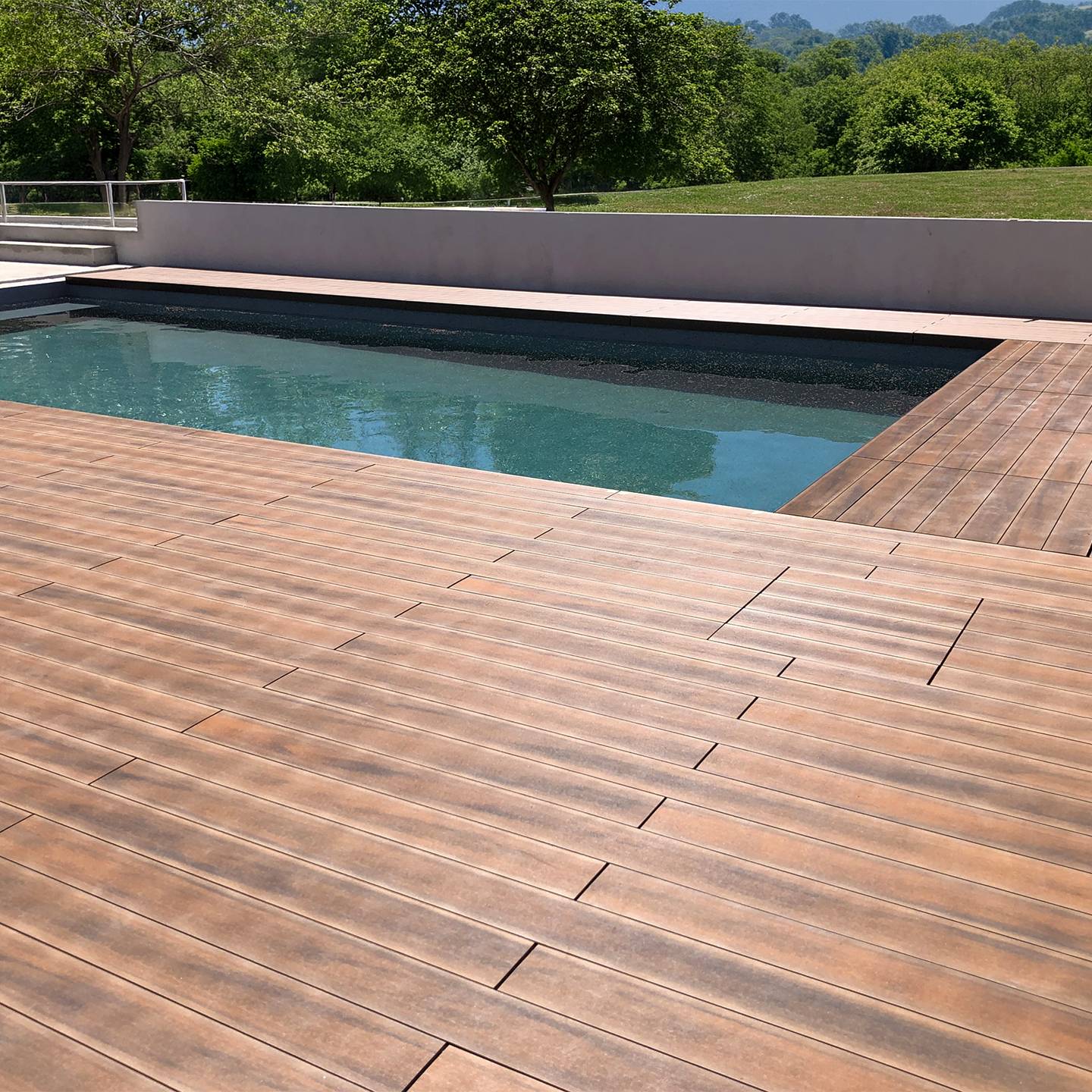 Terrasse en composite CDECK WUUDE couleur american walnut dans une zone de piscine