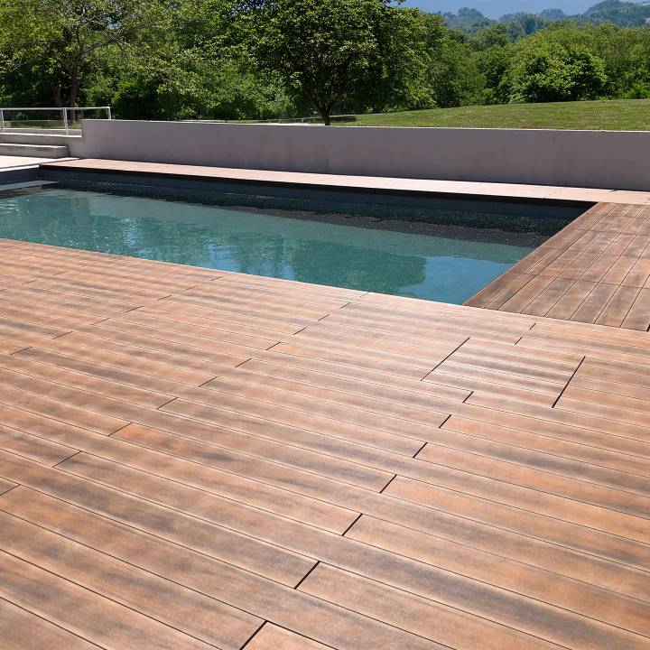 Deck compósito CDECK WUUDE na cor american walnut em zona de piscina