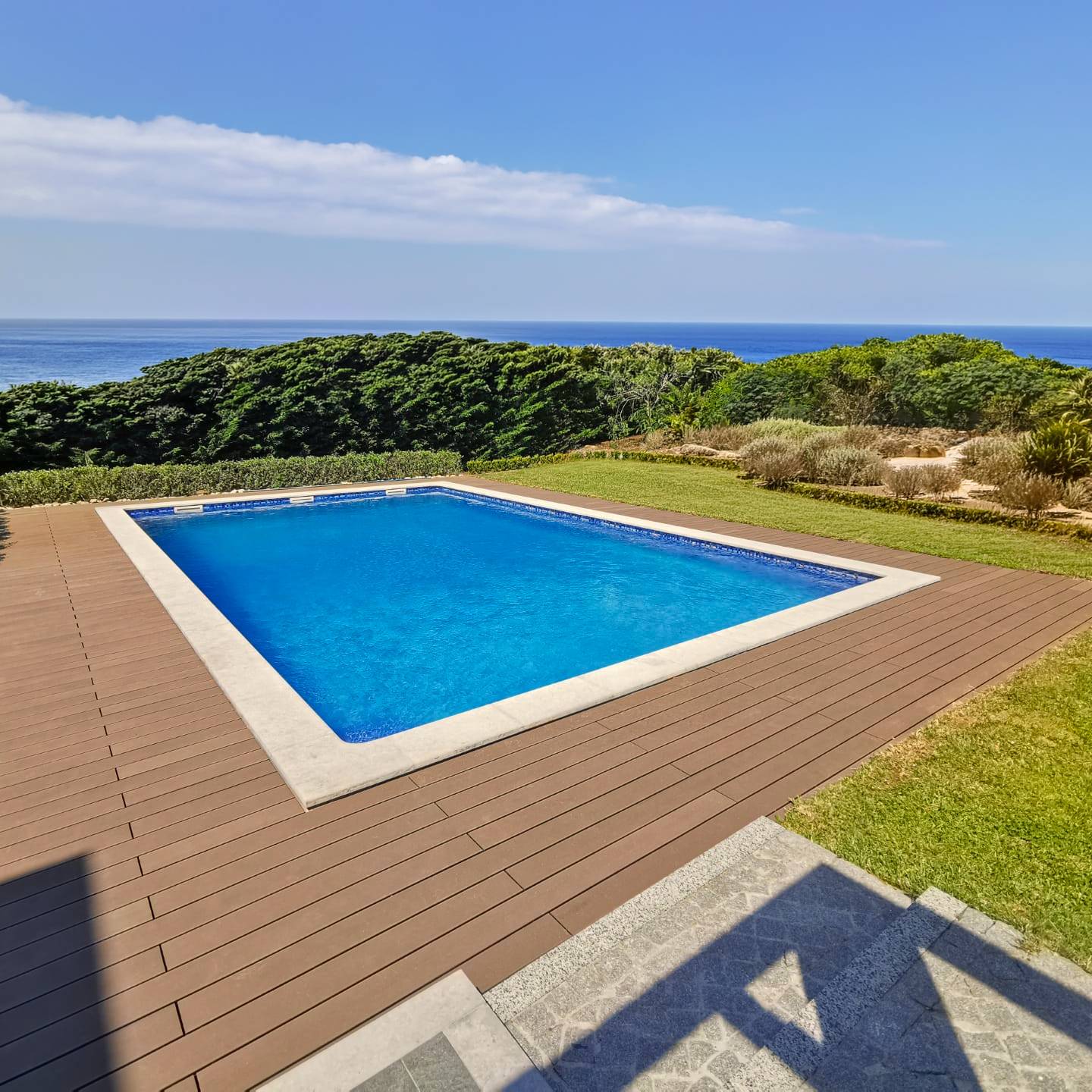 Terrasse en composite CDECK couleur redwood installée dans une zone de piscine et jardin