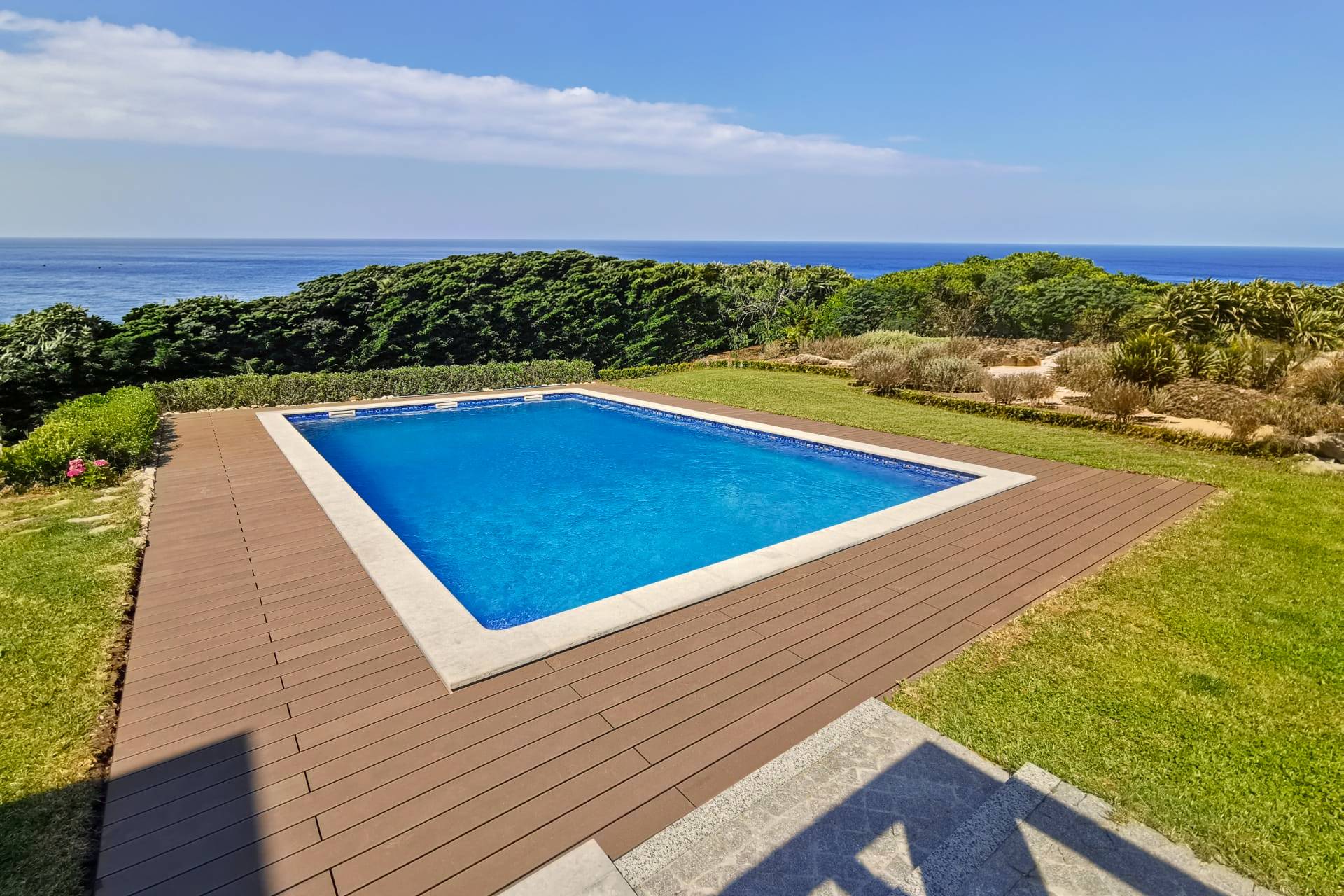 CDECK composite decking in redwood colour installed in a pool and garden area