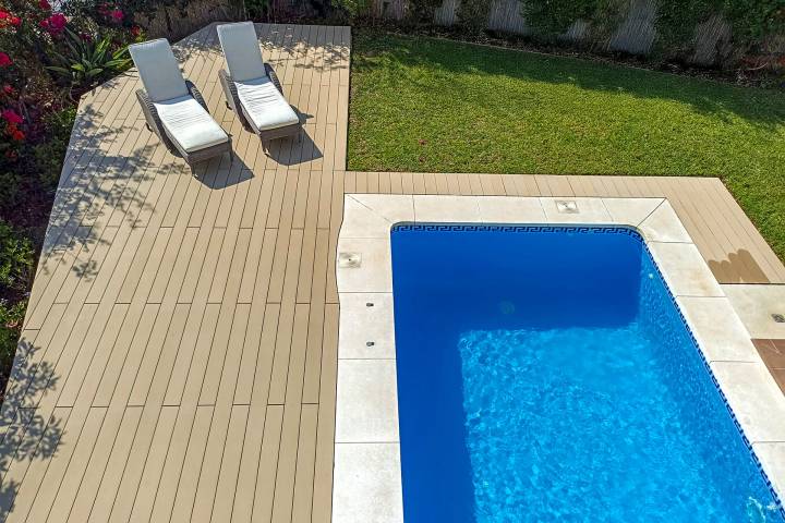 Tarima composite CDECK Original en color haya beige en zona de piscina